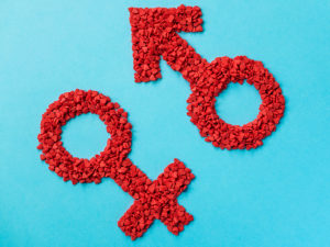 Balancing Masculine and Feminine Energy - Red Gender Symbols Of Small Hearts On A Blue Background. Male An